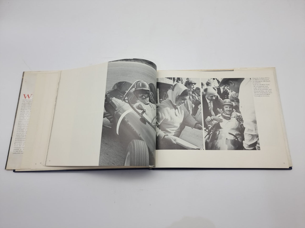 Open black-and-white photo book with group scenes and text columns