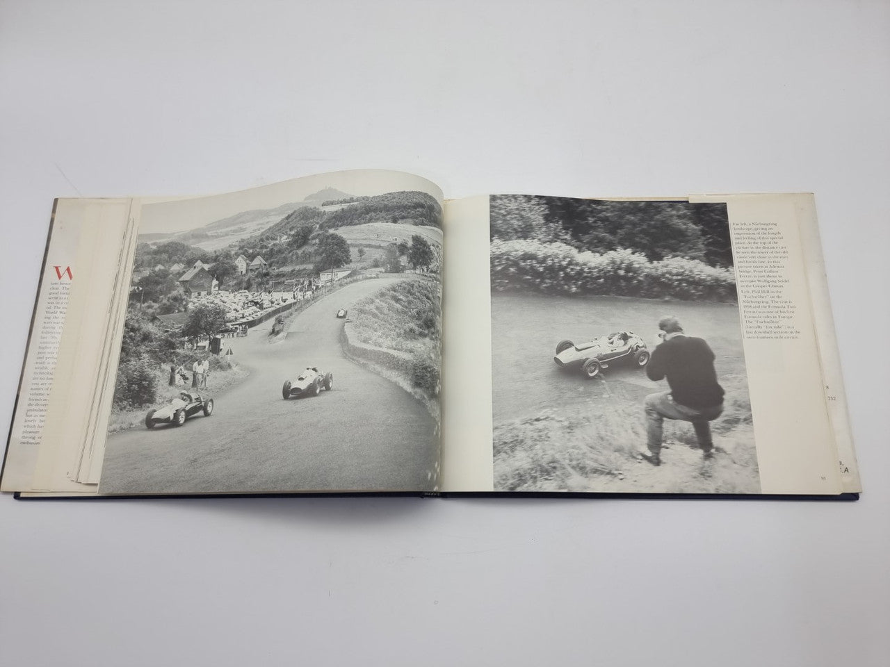 Open vintage photo book with two black-and-white road scenes