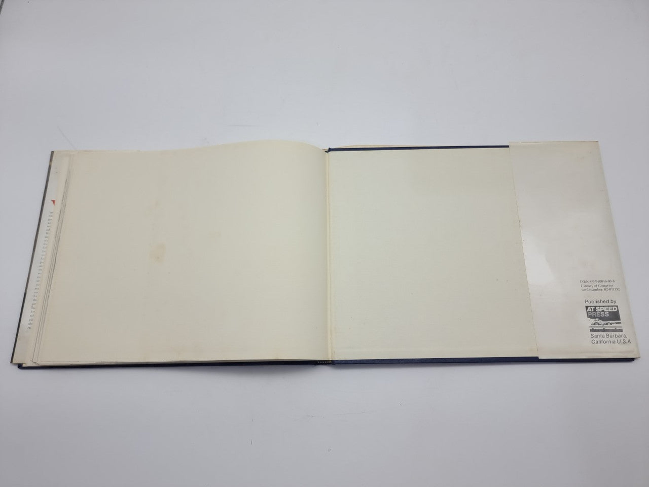 Signed hardcover book open, showing blank pages