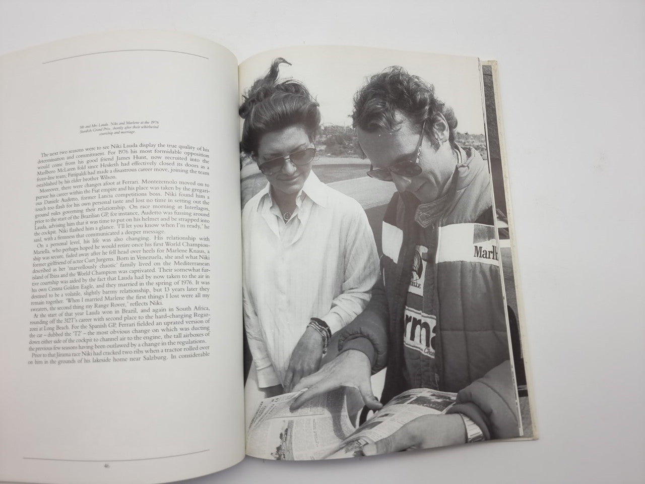 Motorsport book opened to black-and-white photo spread of two people