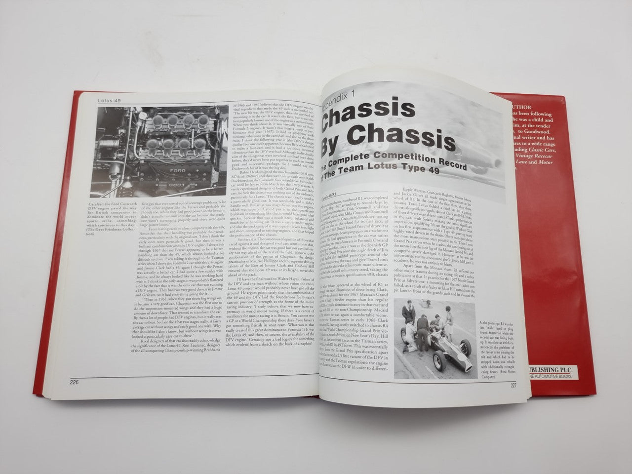 Open hardcover book with red cover, photo and text pages about race car chassis