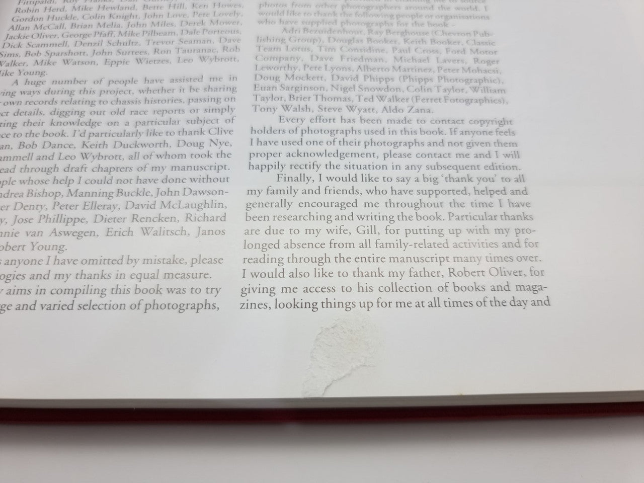 Open book page close-up with dense paragraphs of black text and small footnotes
