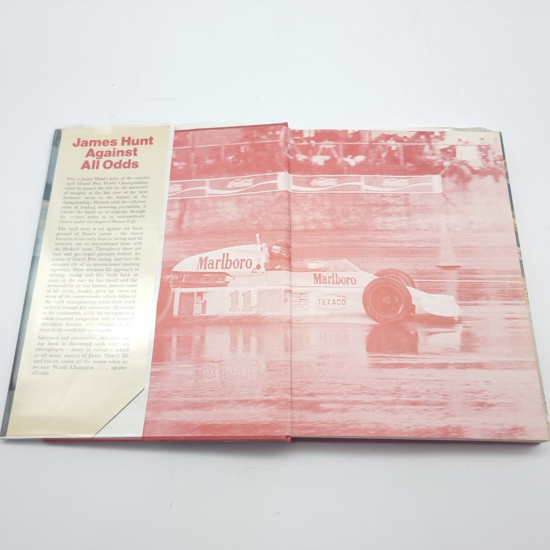 Racing memoir book page spread with large red race car image and side text panel