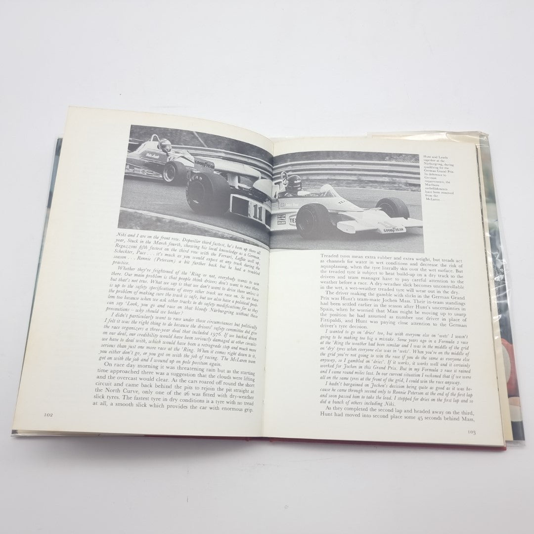 Signed racing memoir book with open pages showing photos and printed text