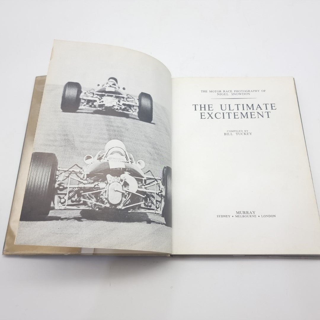 Motor race photography book opened to black-and-white race car photo pages.