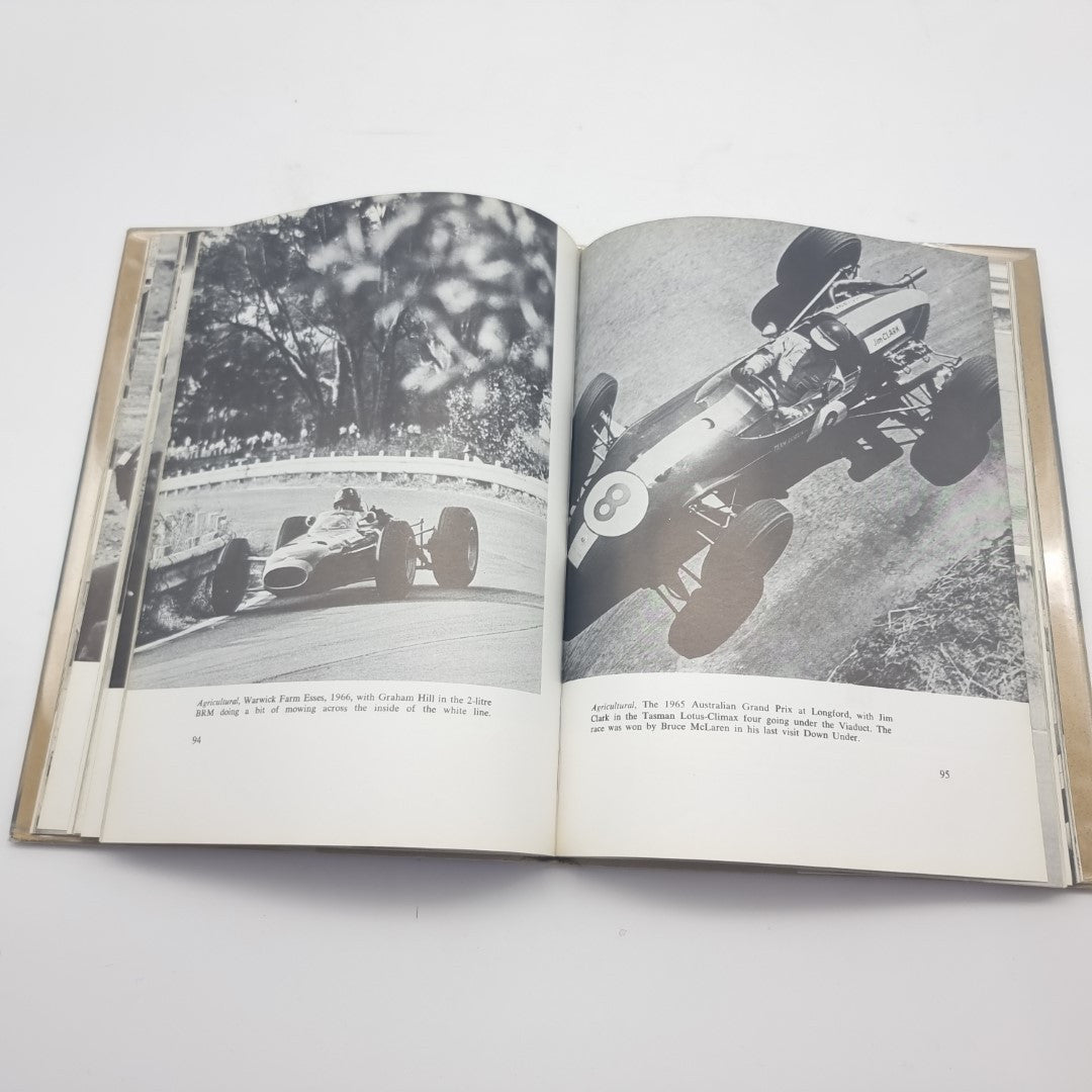 Signed motorsport photography book, open pages with black-and-white race car photos