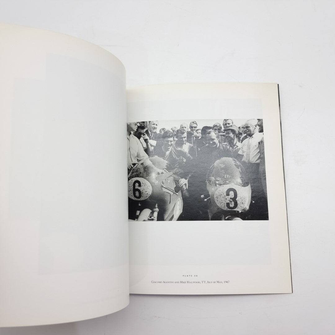 Motor racing photography book open with black-and-white crowd photo and car numbers