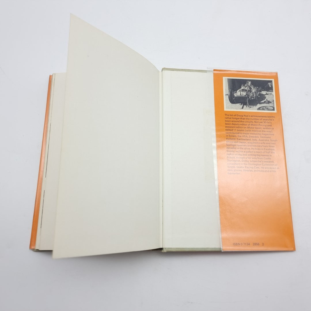 Open vintage book with orange cover insert and black-and-white race photo
