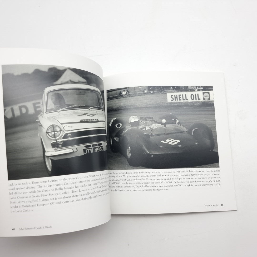 Open motorsport photo book with a vintage race car front view and another car image