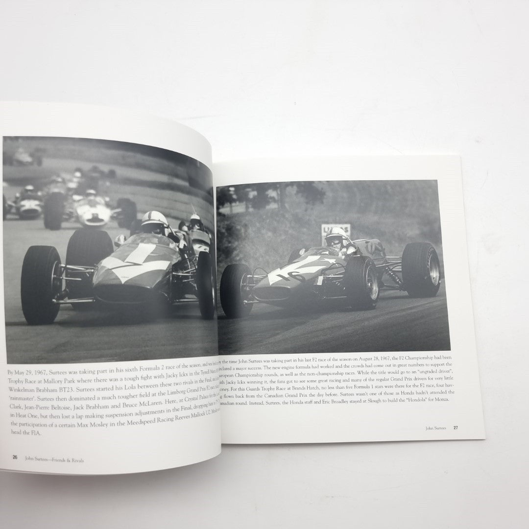 Open motorsport photo book showing two black-and-white race car images on pages