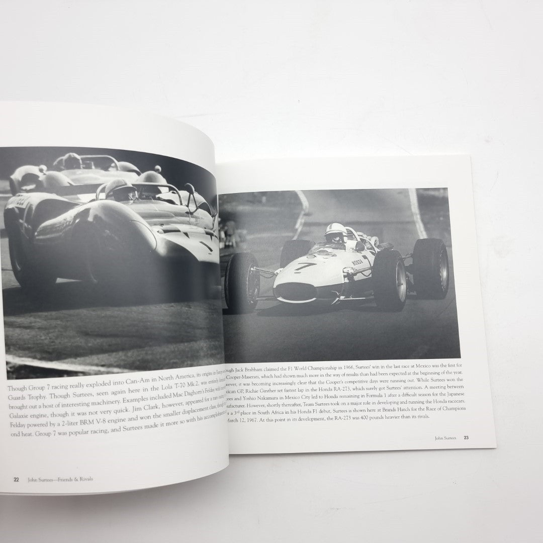 Open motorsport photo book spread featuring black-and-white race cars and track action