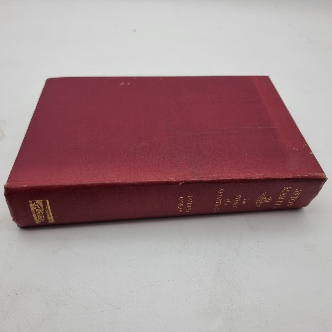 Maroon Aston Martin hardcover book with gold spine details, lying flat