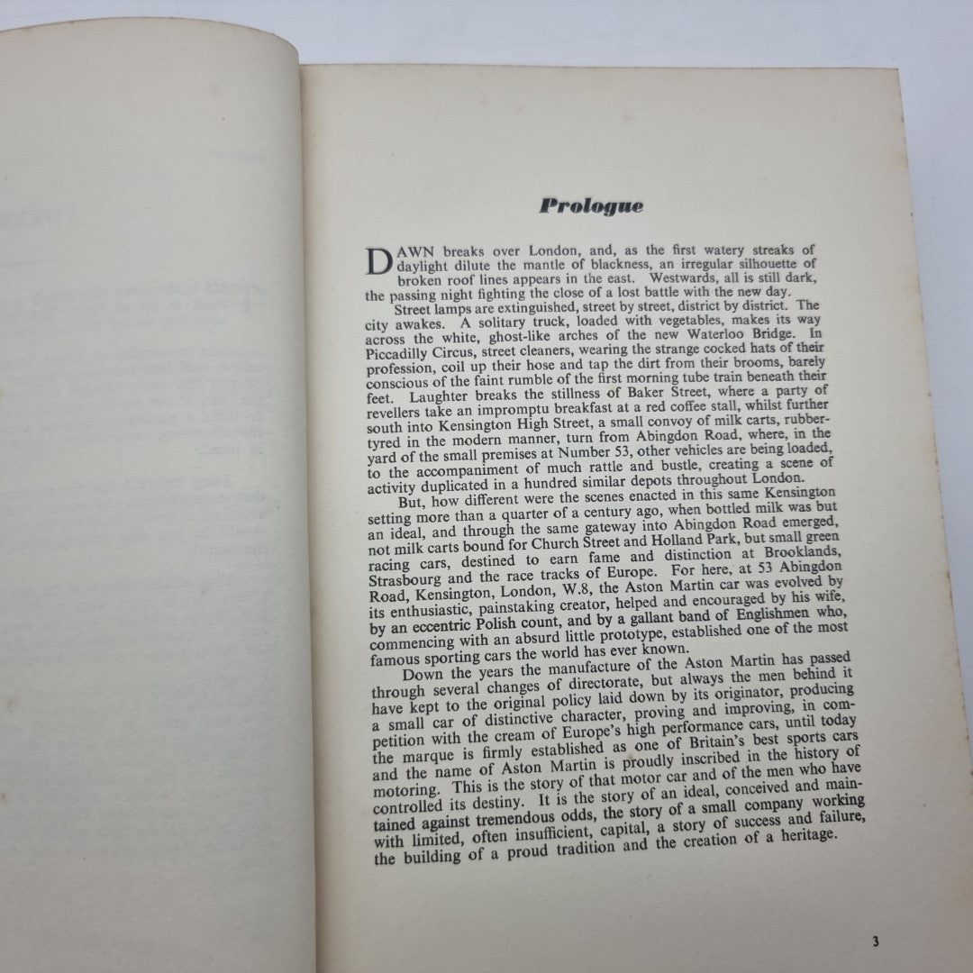 Open Aston Martin book showing Prologue page with text and page number