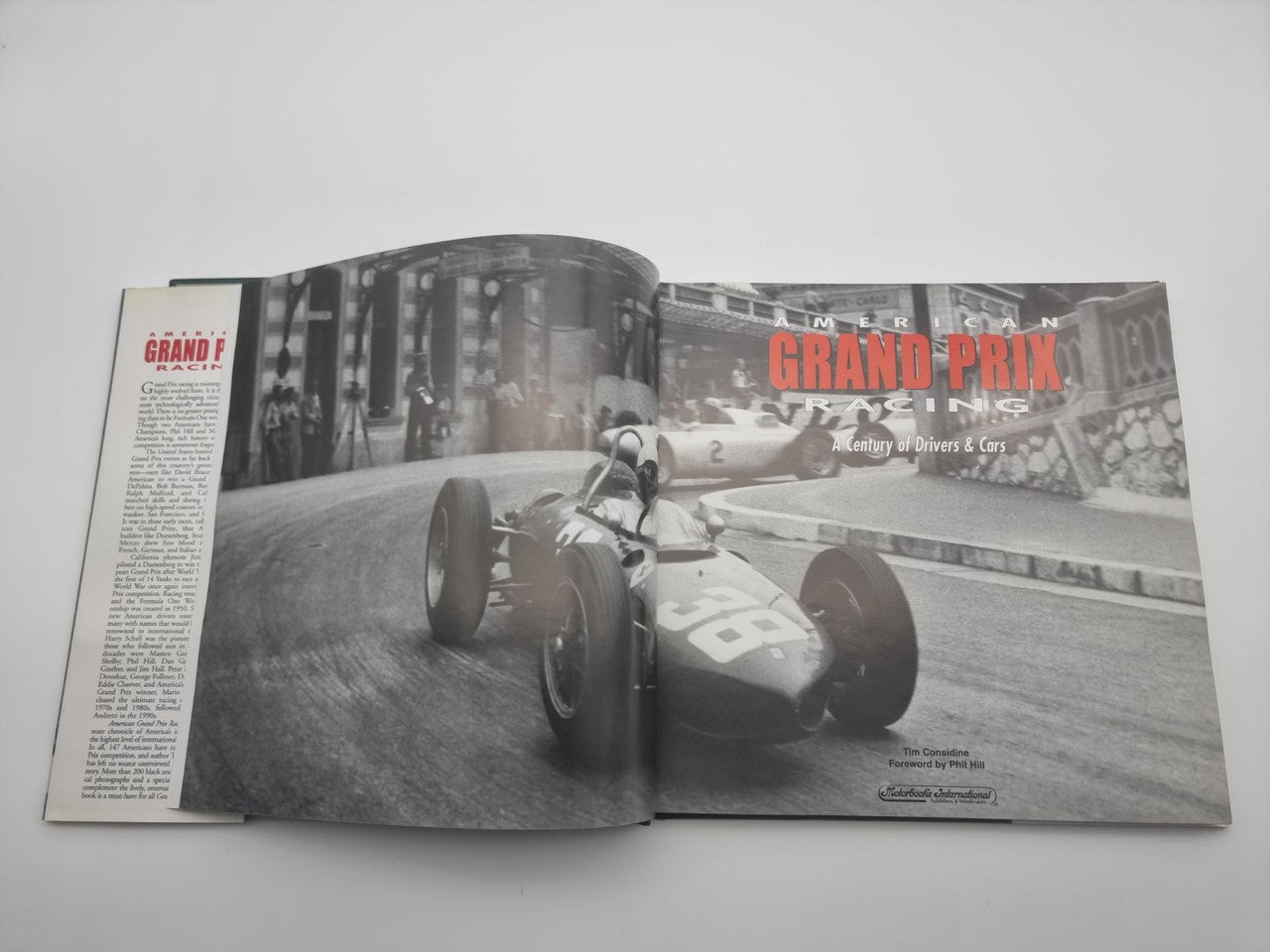 Racing history book, open spread with vintage Grand Prix car photo and text