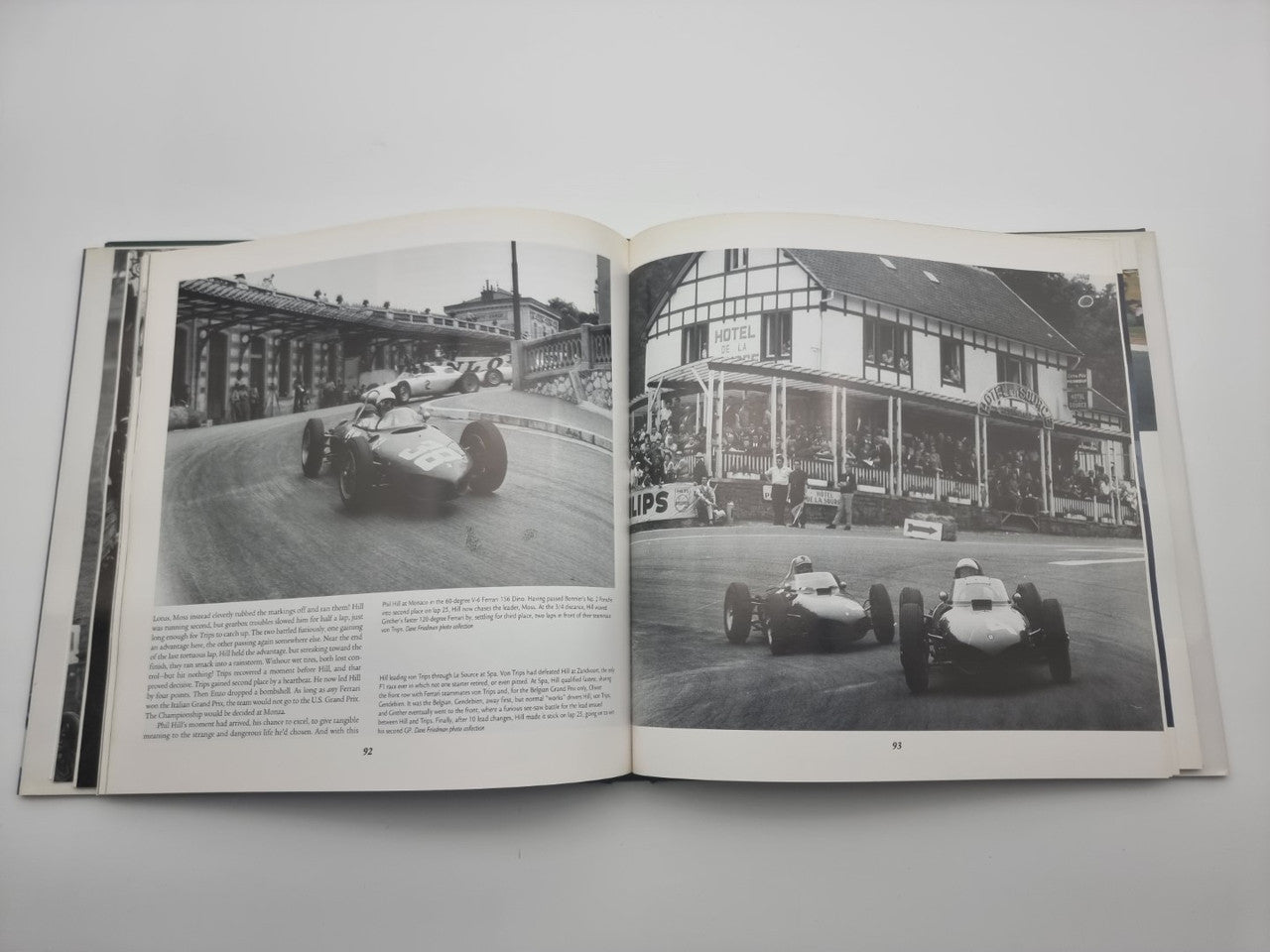 Open book with black-and-white photos of race cars and track buildings