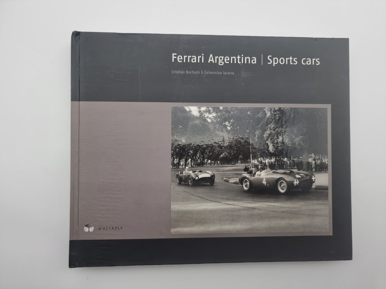Black hardcover sports car book with title and sepia car photo on front cover