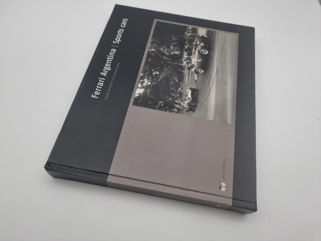 Black hardcover sports car book lying diagonally, front cover with sepia photo