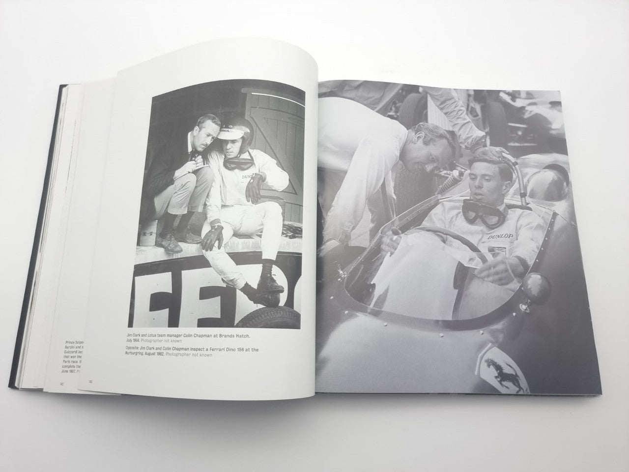 Open motor racing photo book with driver portrait and cockpit action photo