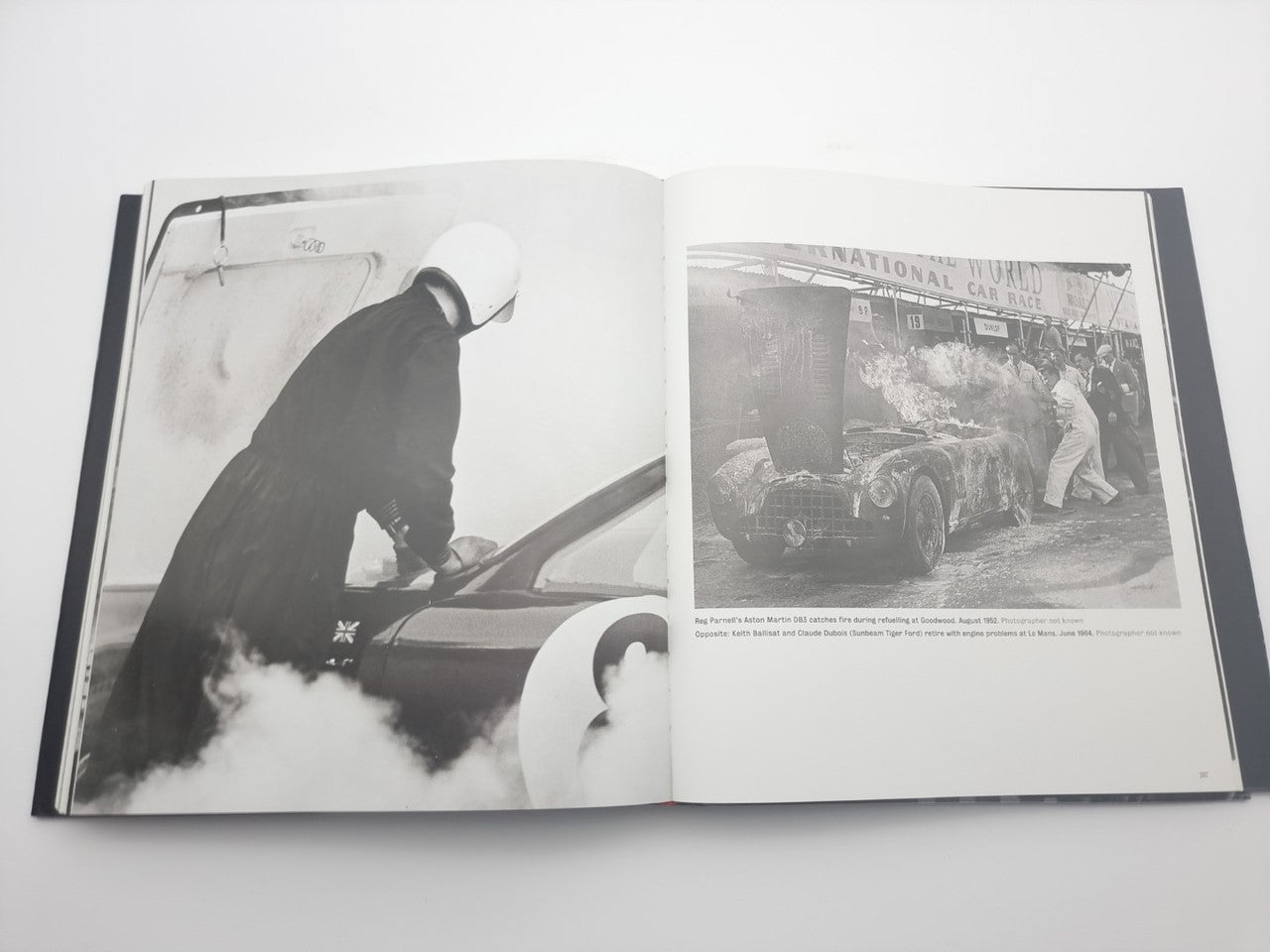 Open motor racing photo book showing driver at wheel and crowd race photo