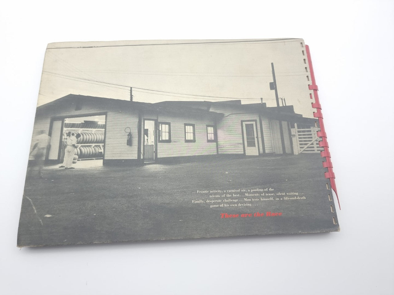 Vintage photo book back cover with building photo and red spiral binding.