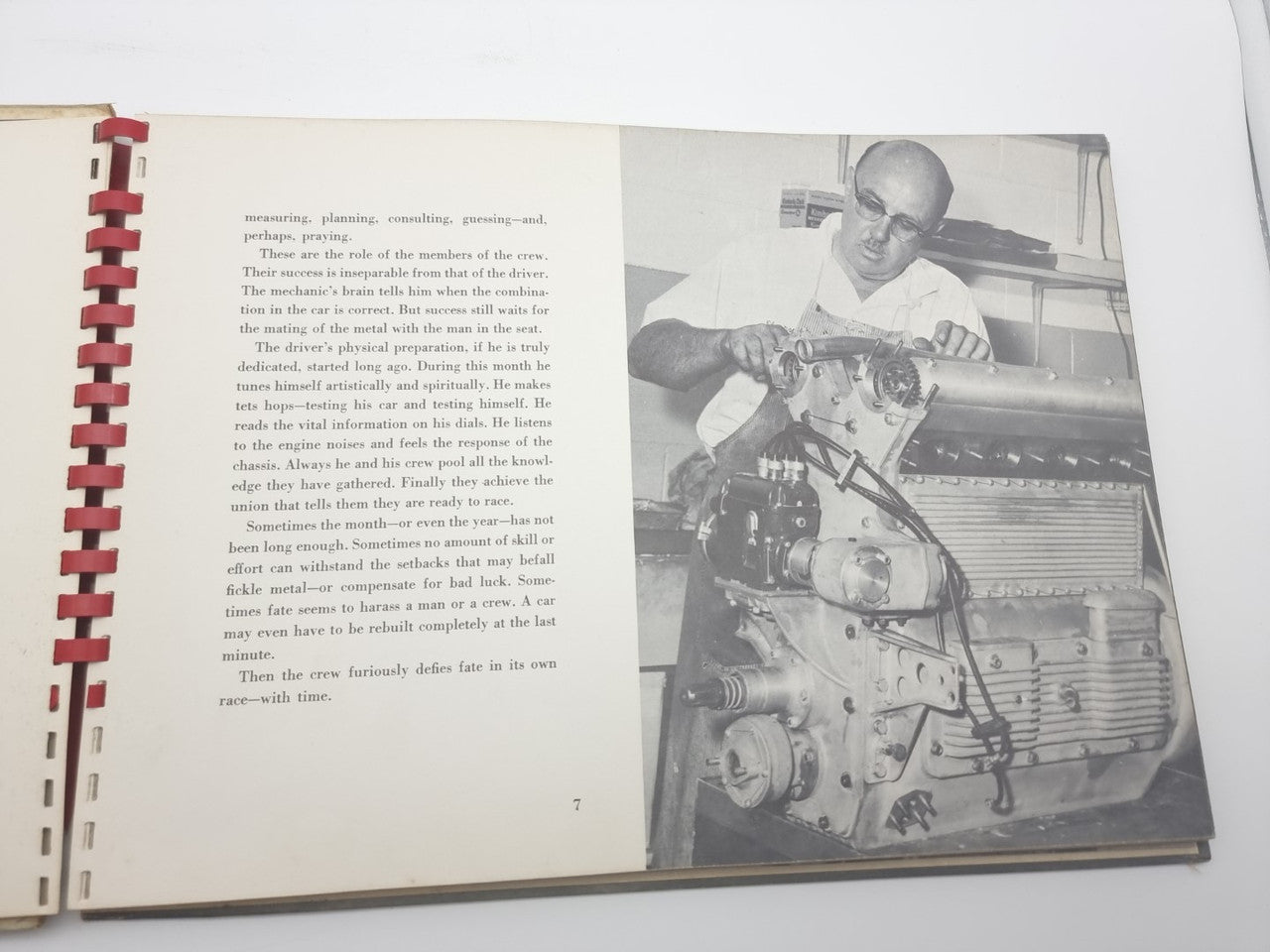 Open book spread with printed text and black-and-white photo of a driver at a dashboard.