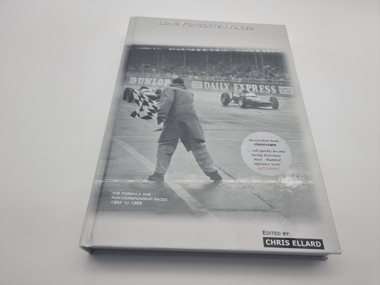 Hardcover motorsport racing history book front cover with cars, Daily Express text, and editor name