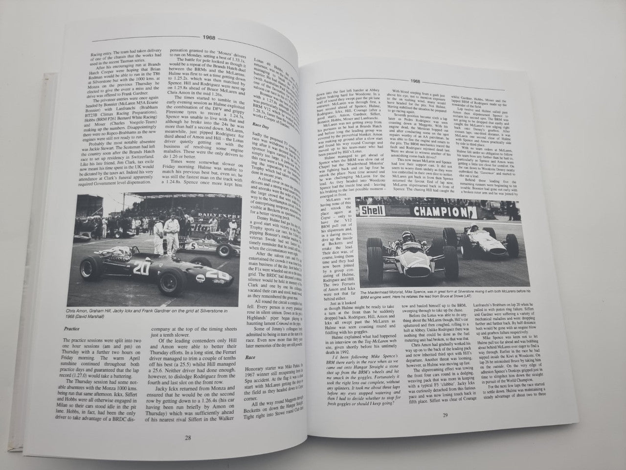 Race history book open to article pages with multiple racing car photos and dense text
