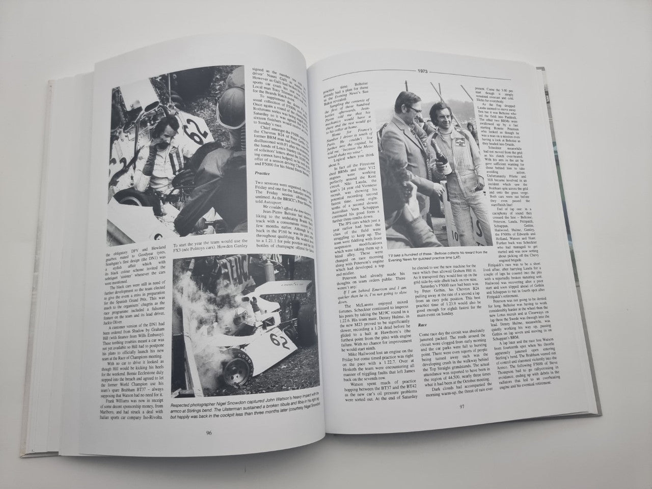 Race history book open to black-and-white racing photos and driver portraits
