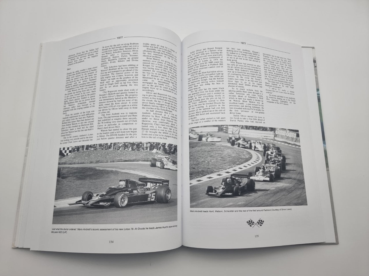 Race history book open, pages showing two black-and-white track photos and captions