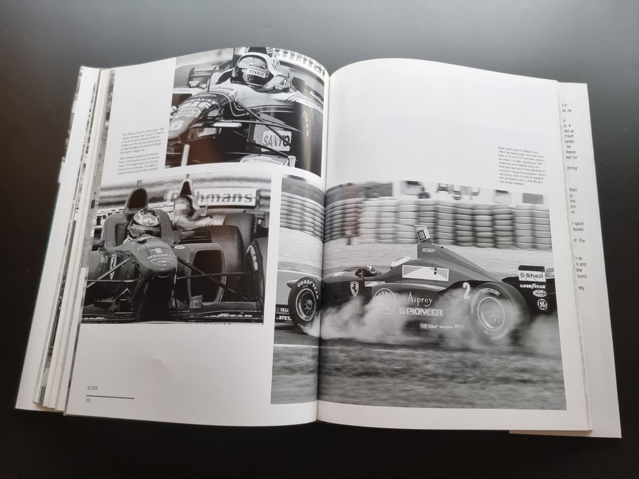 Open hardcover racing photo book with black-and-white car images on both pages