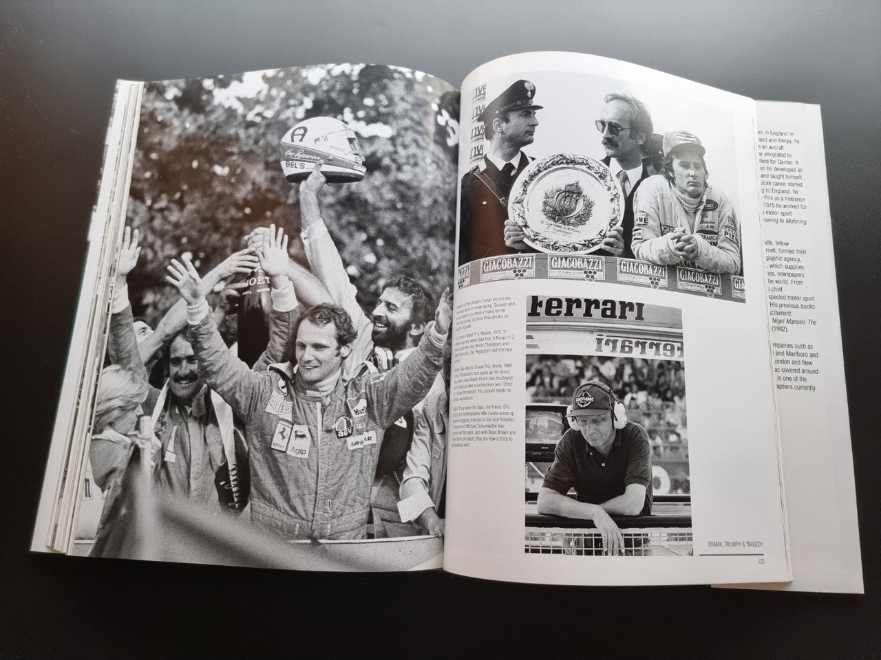 Open hardcover racing photo book with black-and-white portraits and race cars on pages