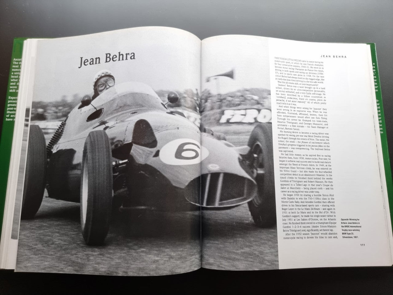 Open motorsport history book with black-and-white Formula 1 car photo and page text
