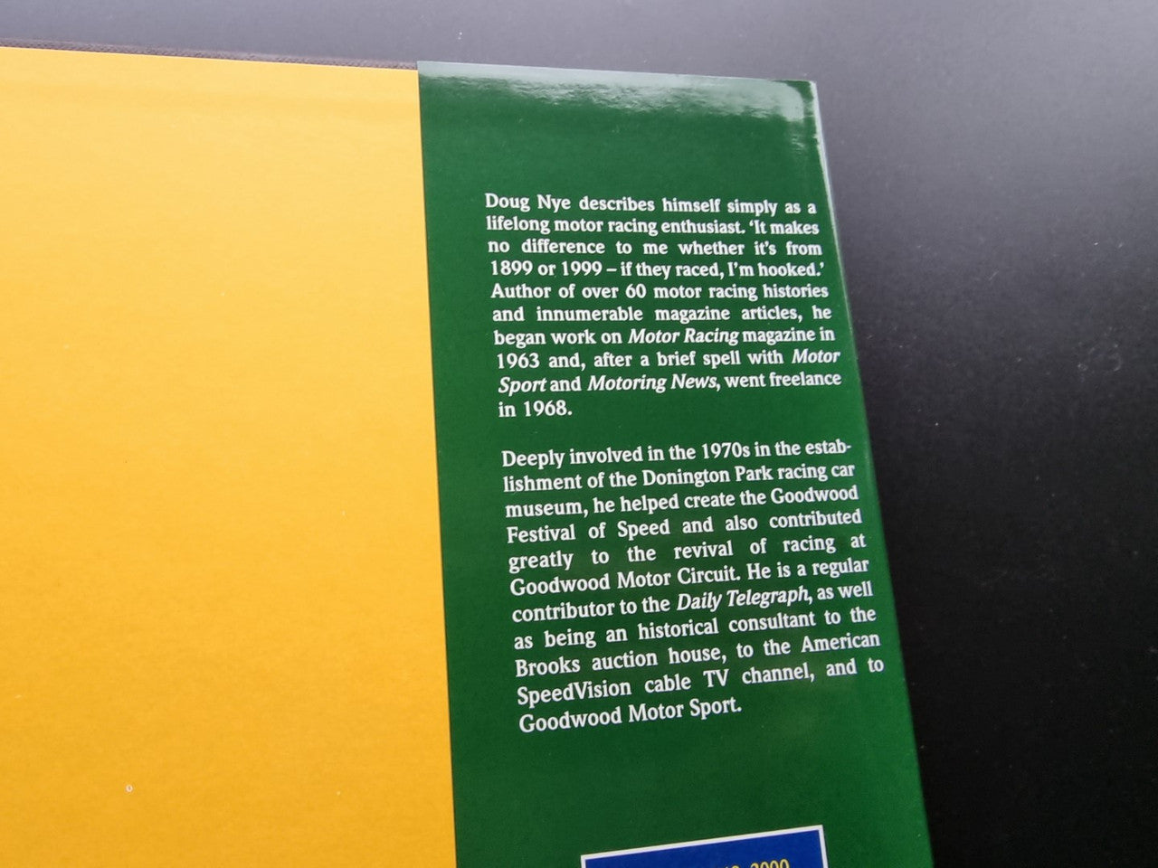 Motorsport history book page with yellow and green sections and a short author biography
