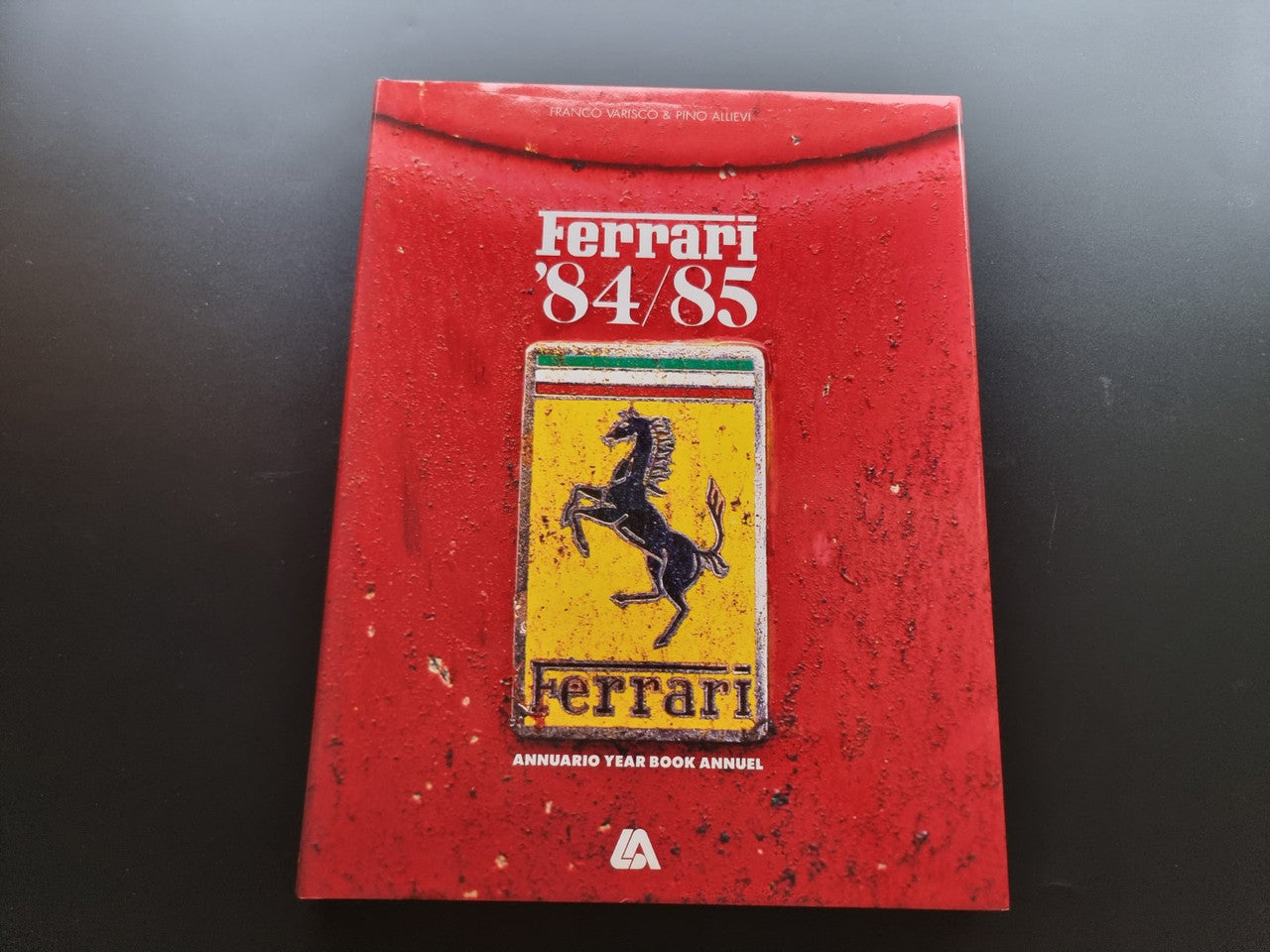Red Ferrari 84-85 year book annual cover with yellow shield logo