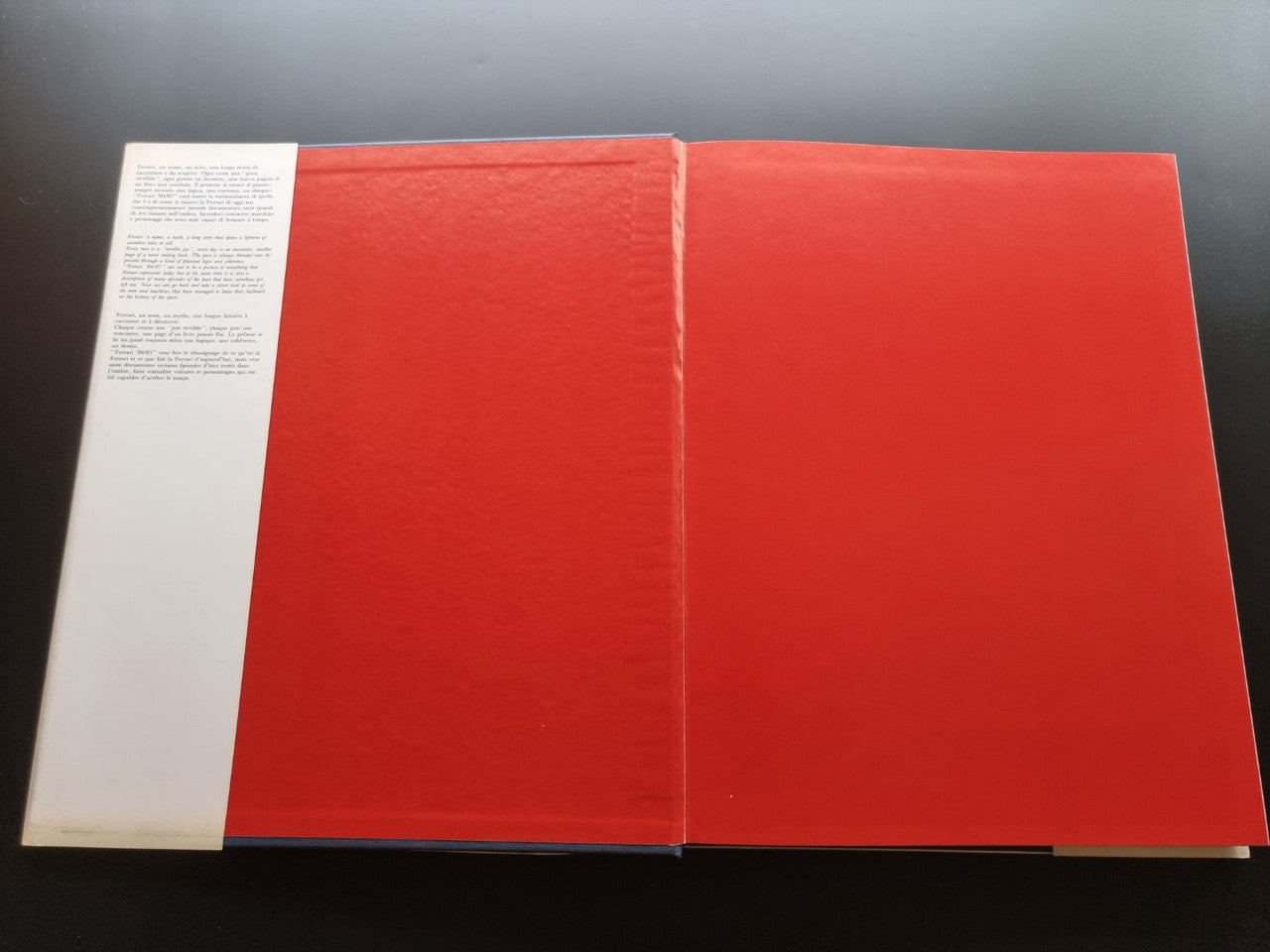 Ferrari year book with red cover and white page section, opened flat