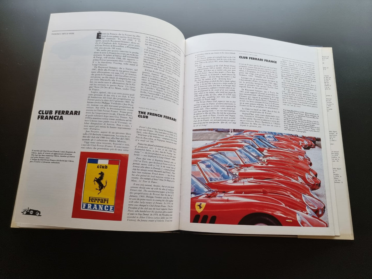 Open year book with Ferrari club logo and close-up red race car