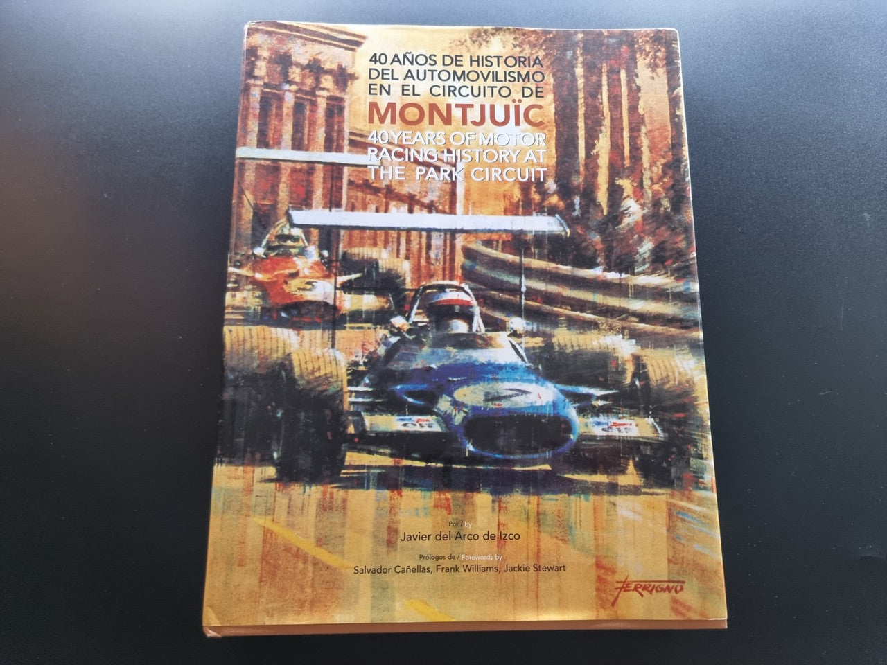 Front cover of a vintage racing history book with a car on a track