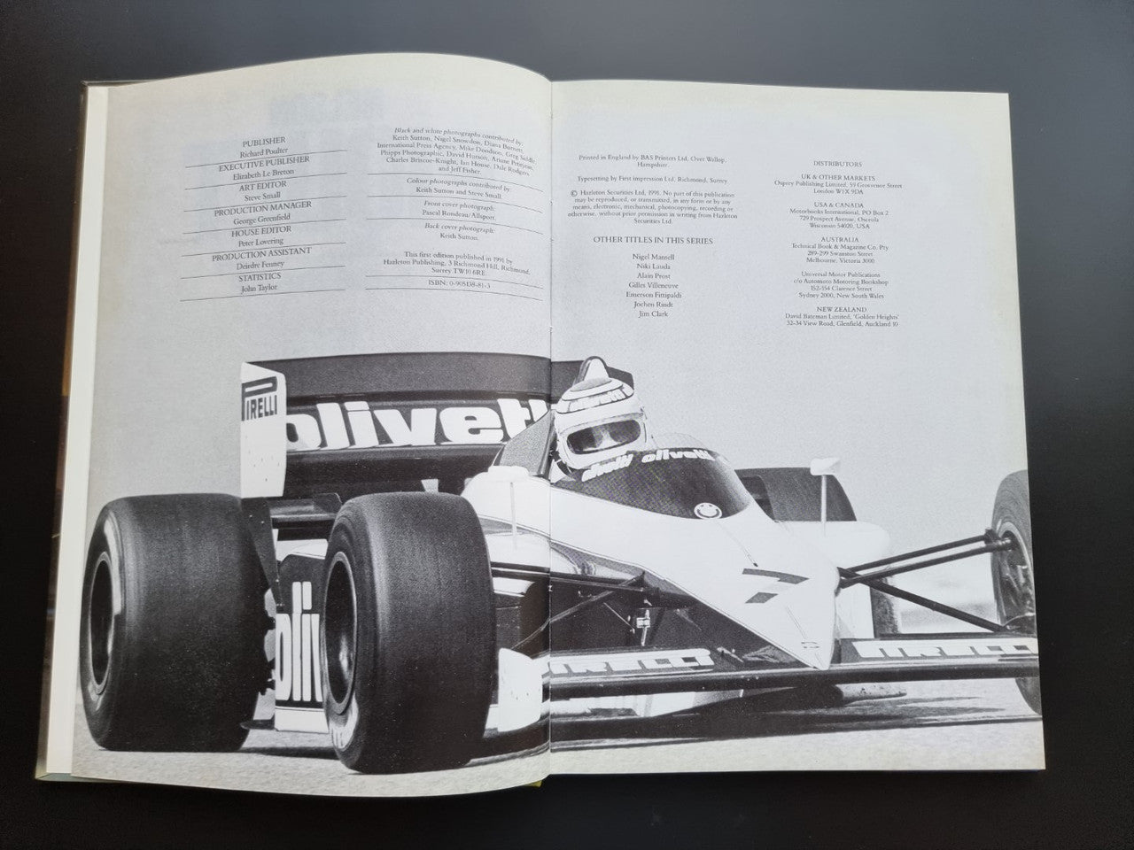 Open motorsport book pages with black-and-white photo of a race car
