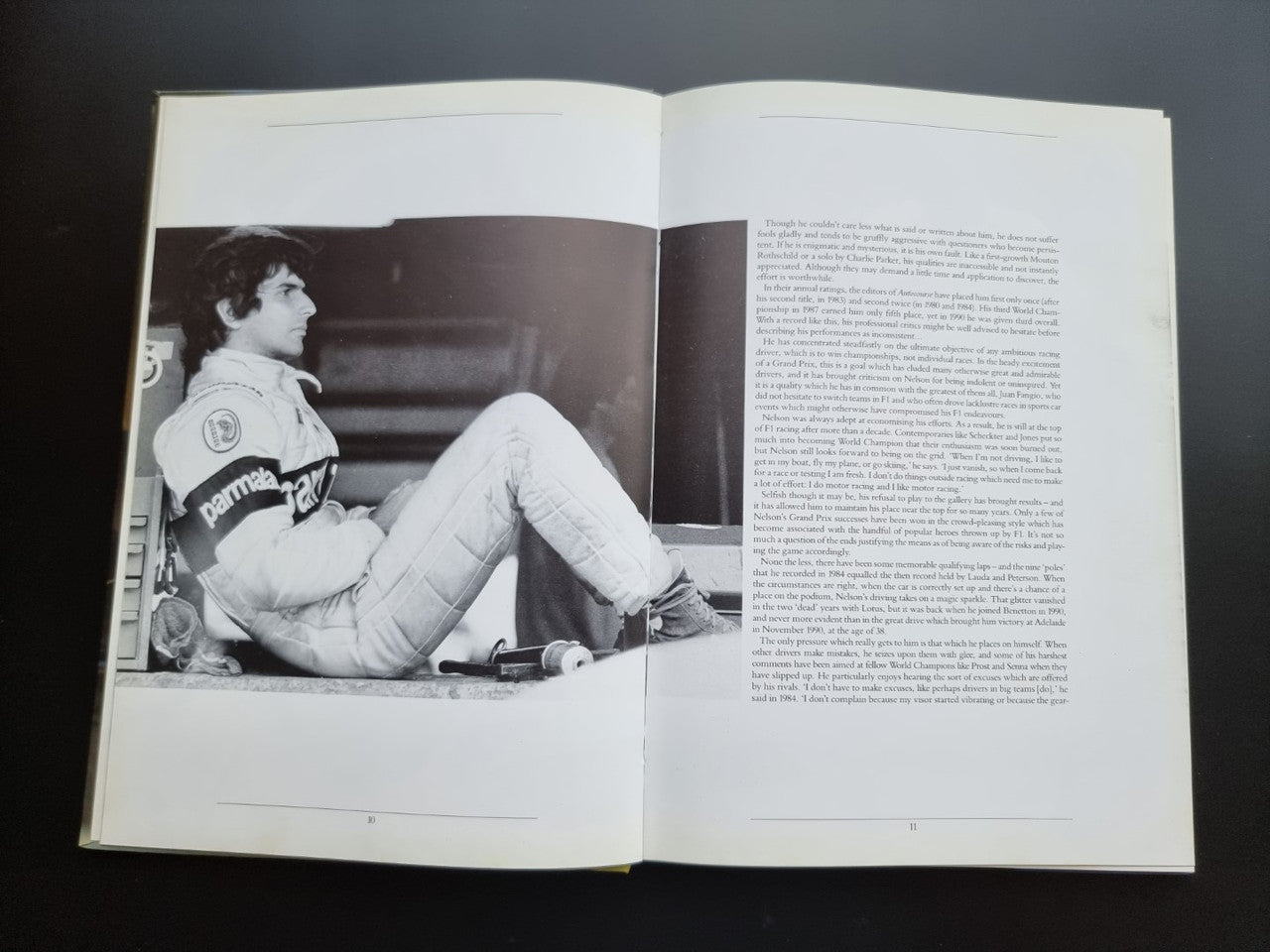 Open motorsport book pages with black-and-white driver sitting pose