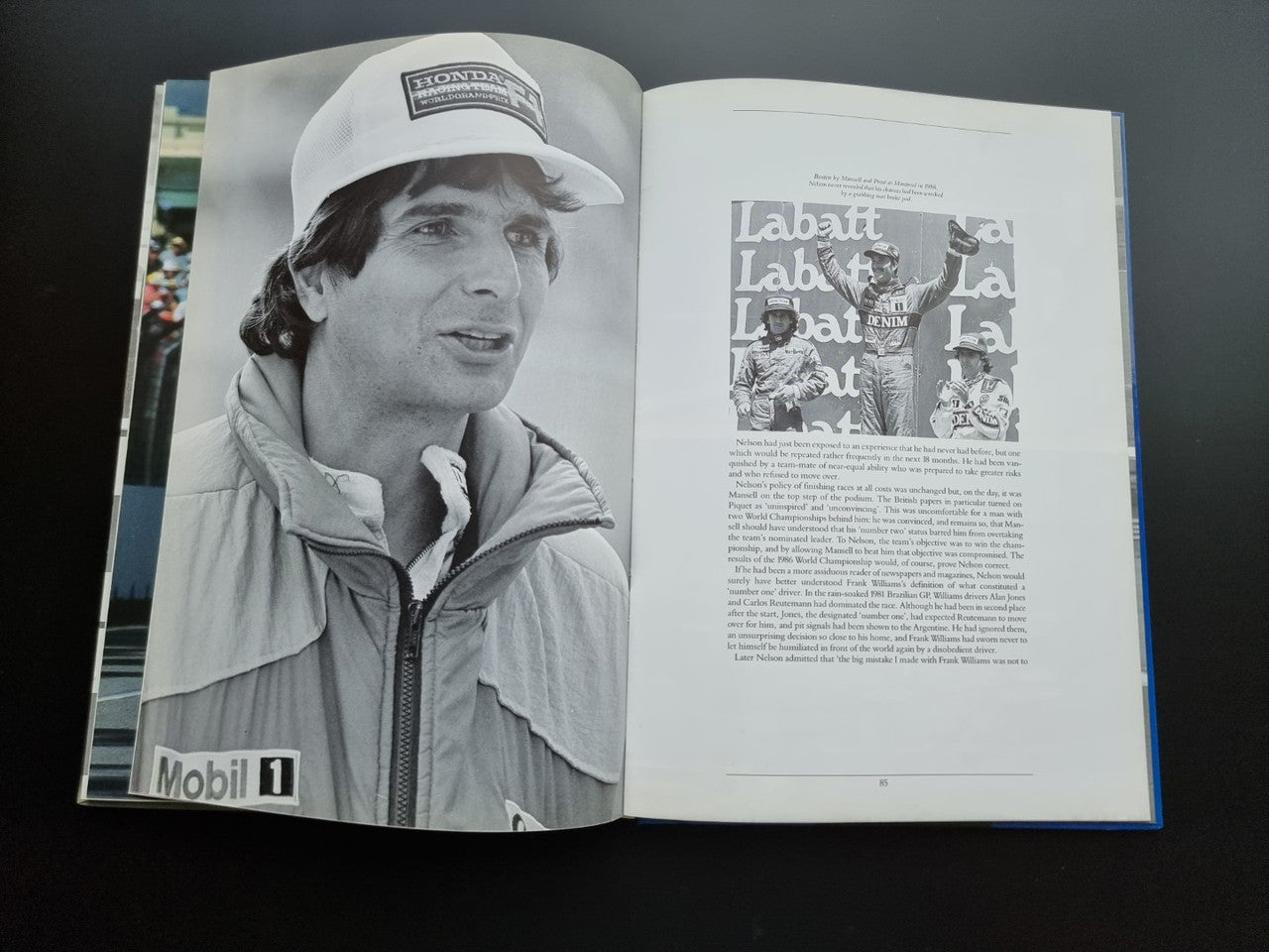 Open motorsport book pages with black-and-white portrait in a cap and jacket