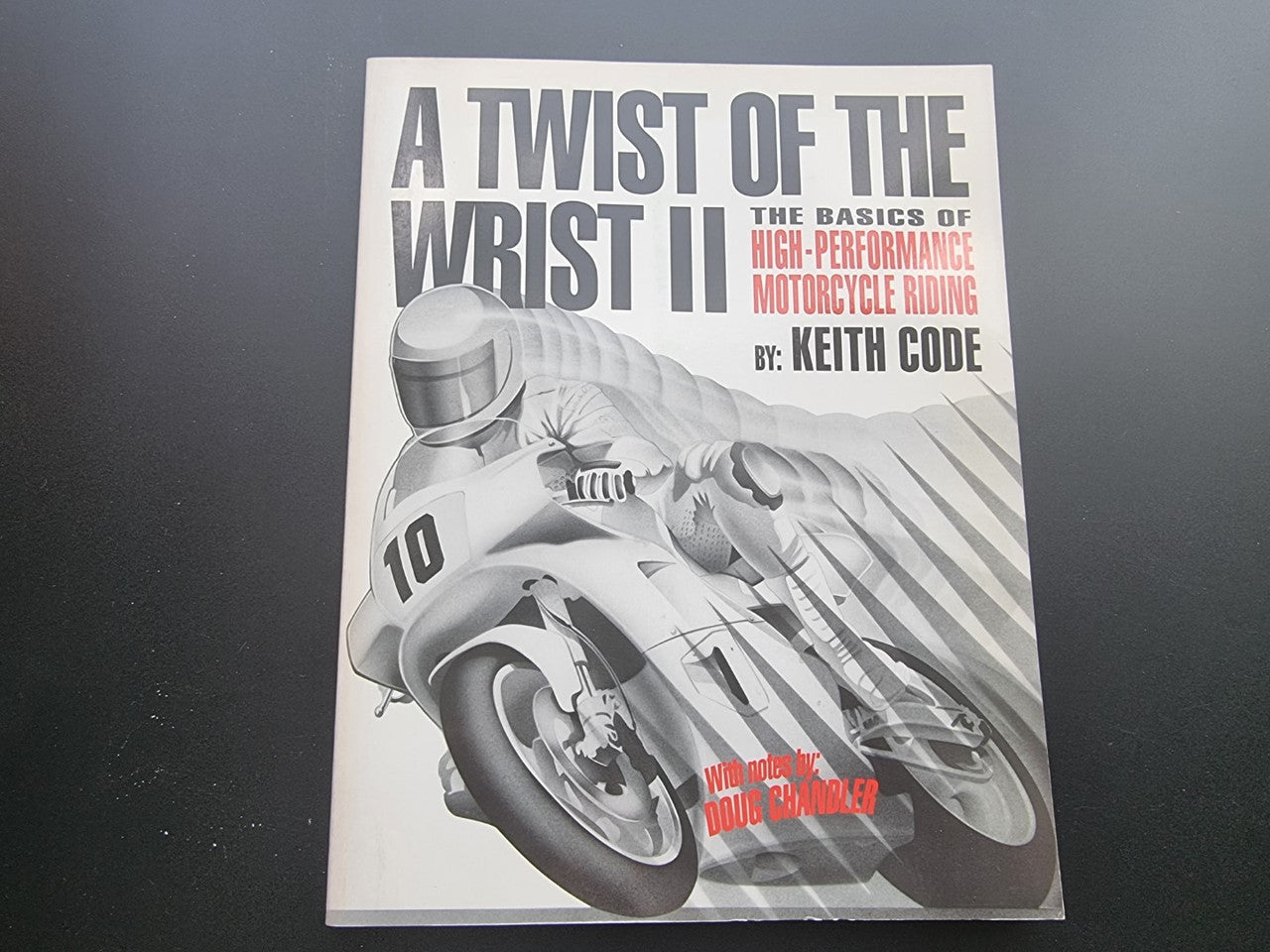 Motorcycle riding guide paperback, black-and-white cover with helmeted rider and title text.