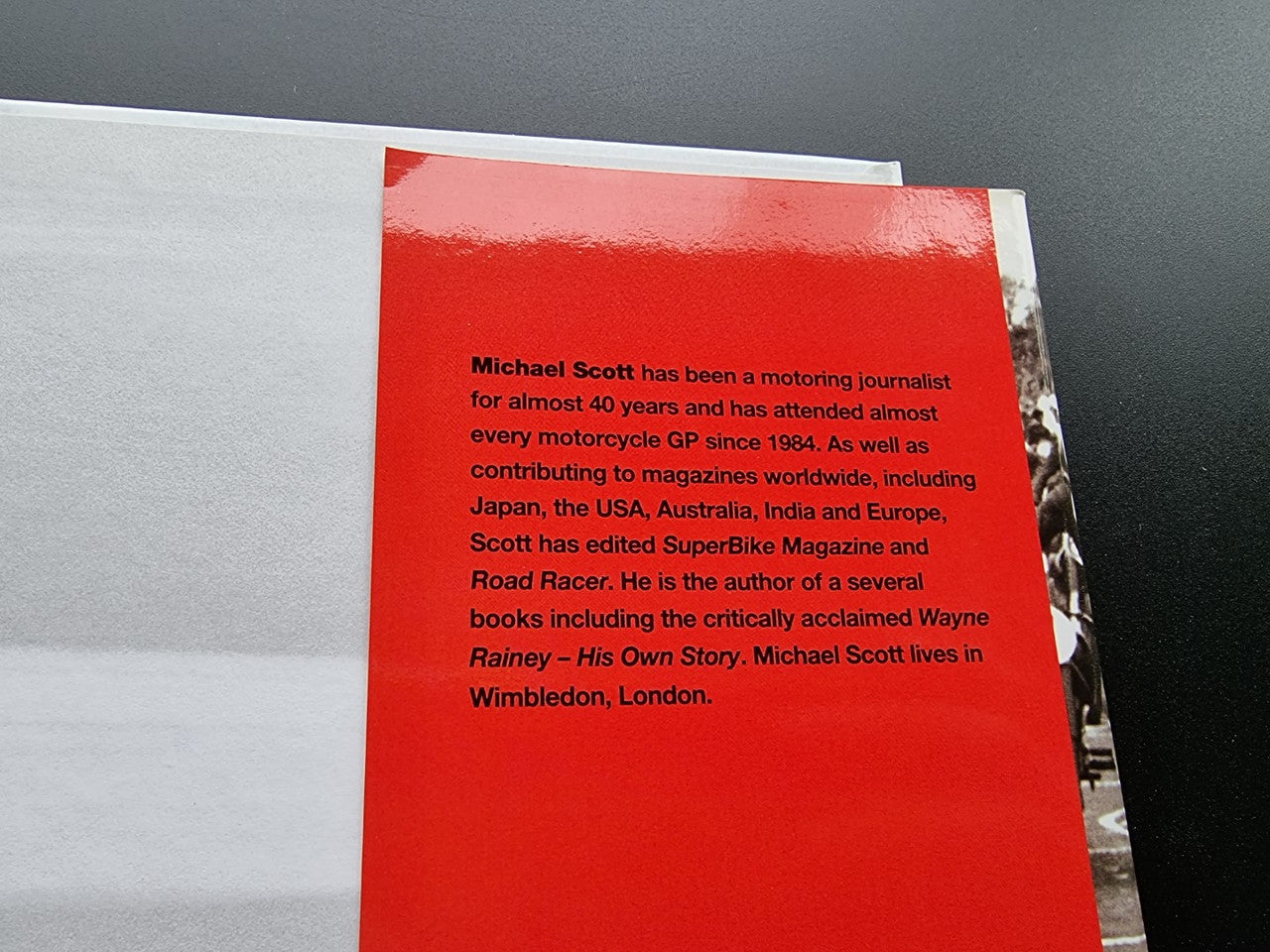 Motorsport history book page with red background and short biography paragraph