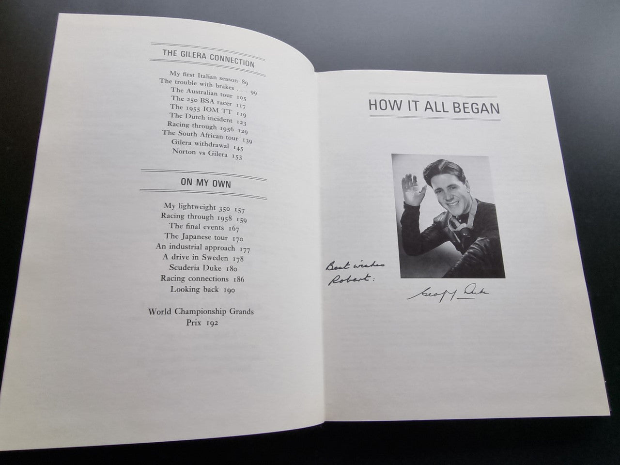 Open book spread with handwritten Geoff Duke signature photo and text headings