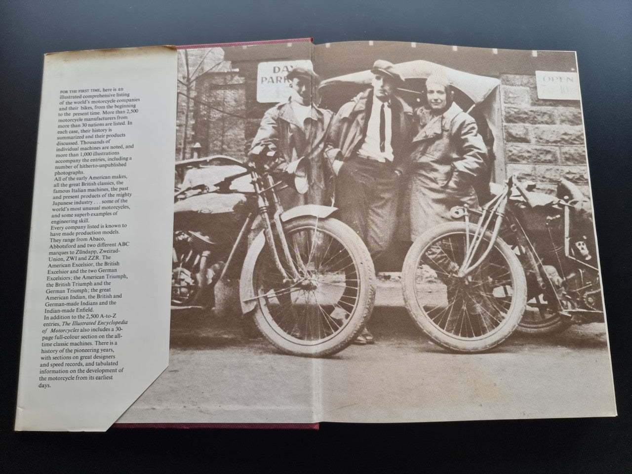 Open encyclopedia spread with black-and-white motorcycles and paragraphs on left