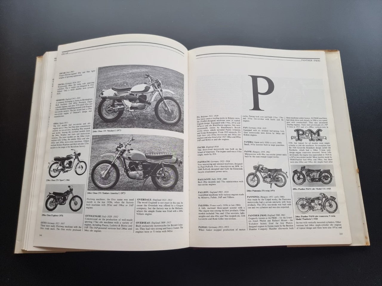 Illustrated motorcycle encyclopedia book, open pages with large letter heading and motorcycle diagrams