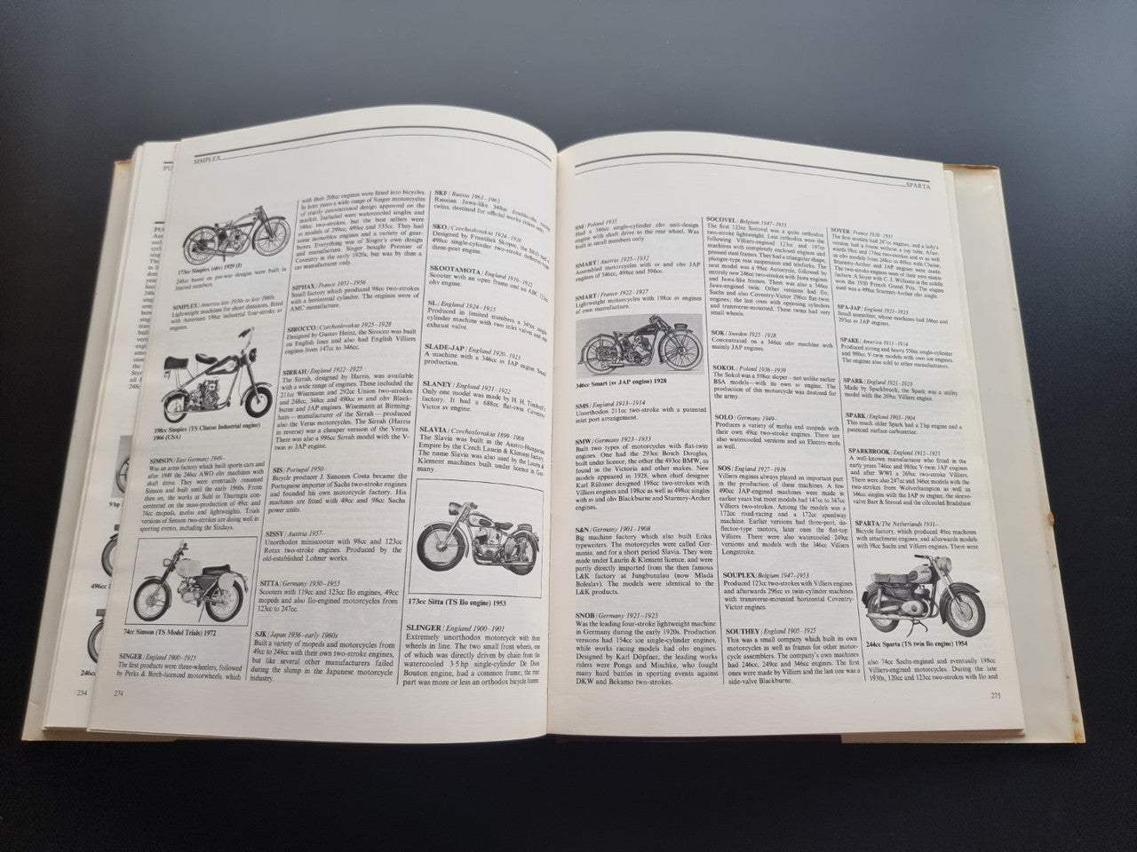 Illustrated motorcycle encyclopedia book, open spread with small motorcycle illustrations and captions