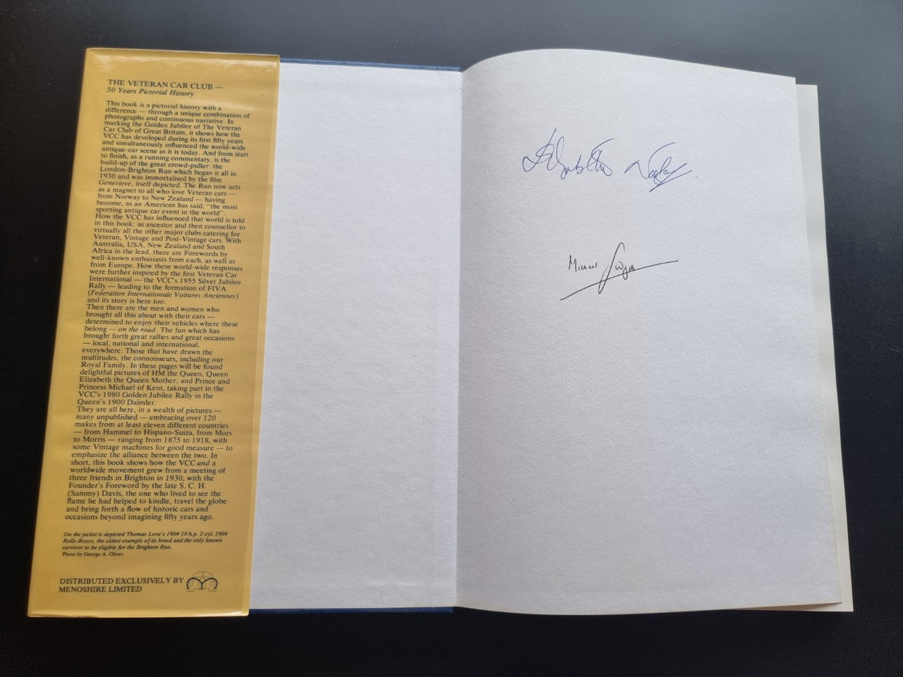 Signed pictorial history book open spread with handwritten autographs