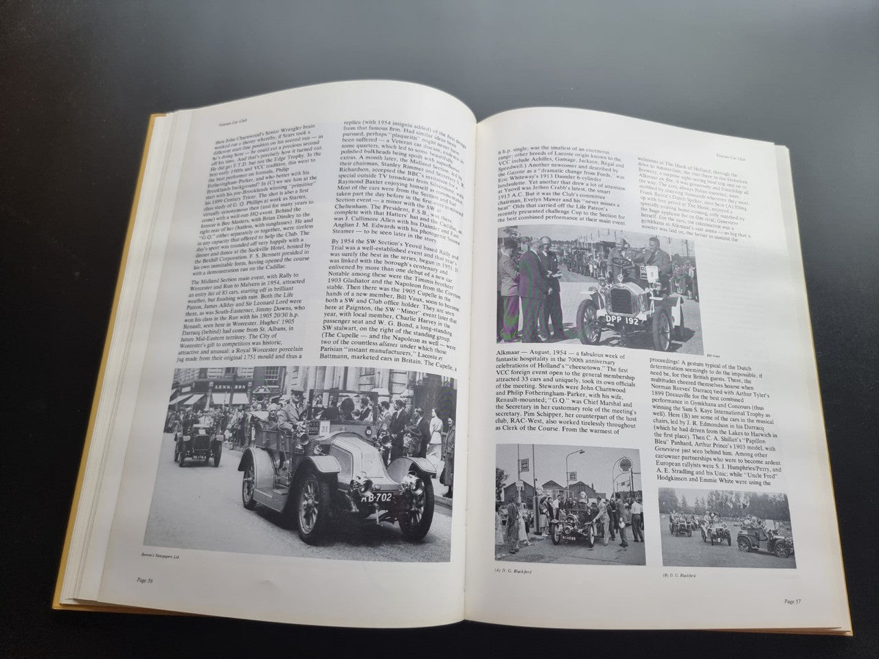 Open pictorial history book spread with black-and-white car and crowd photos