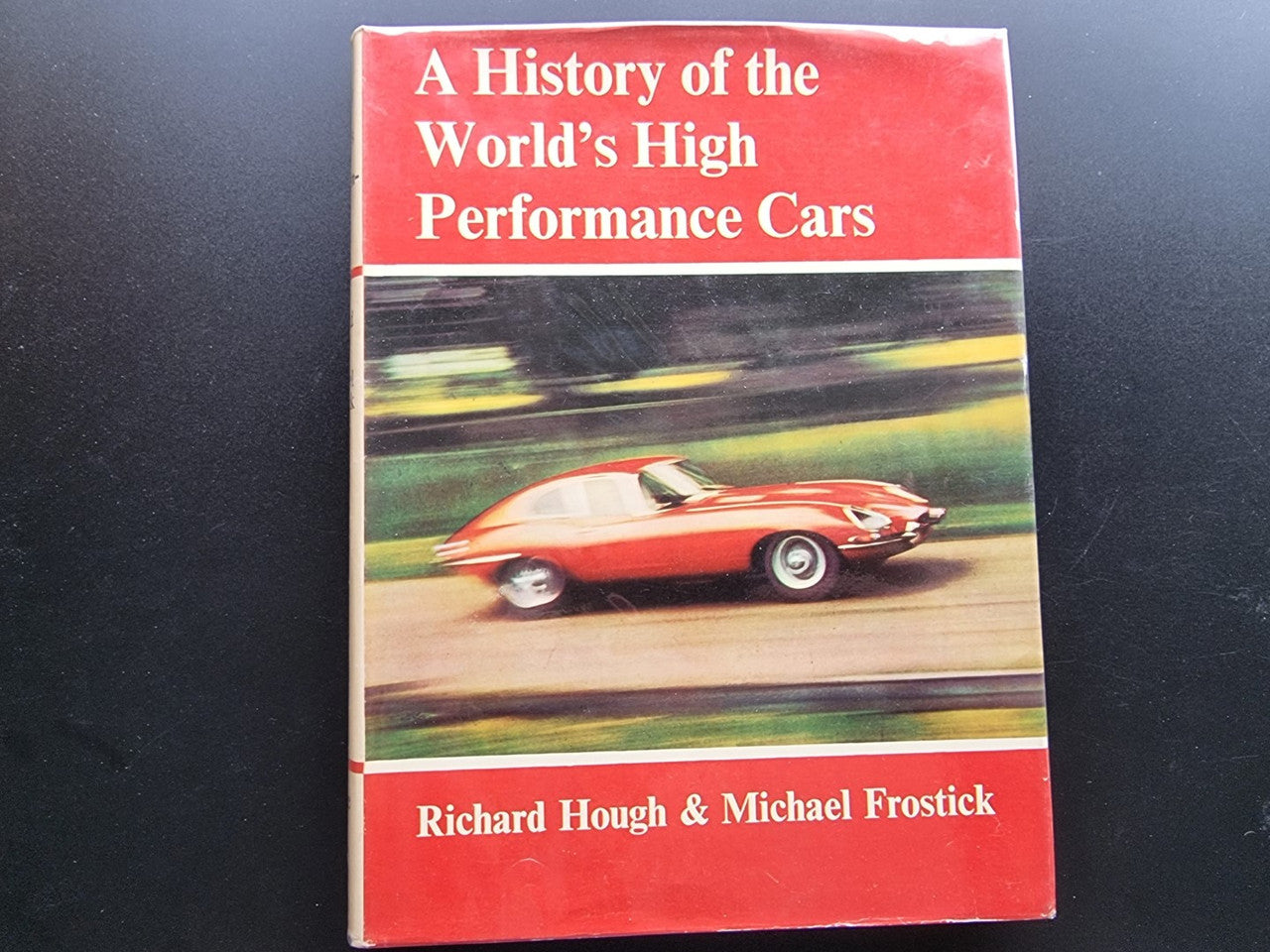 Book cover with red title band and photo of a classic red sports car.