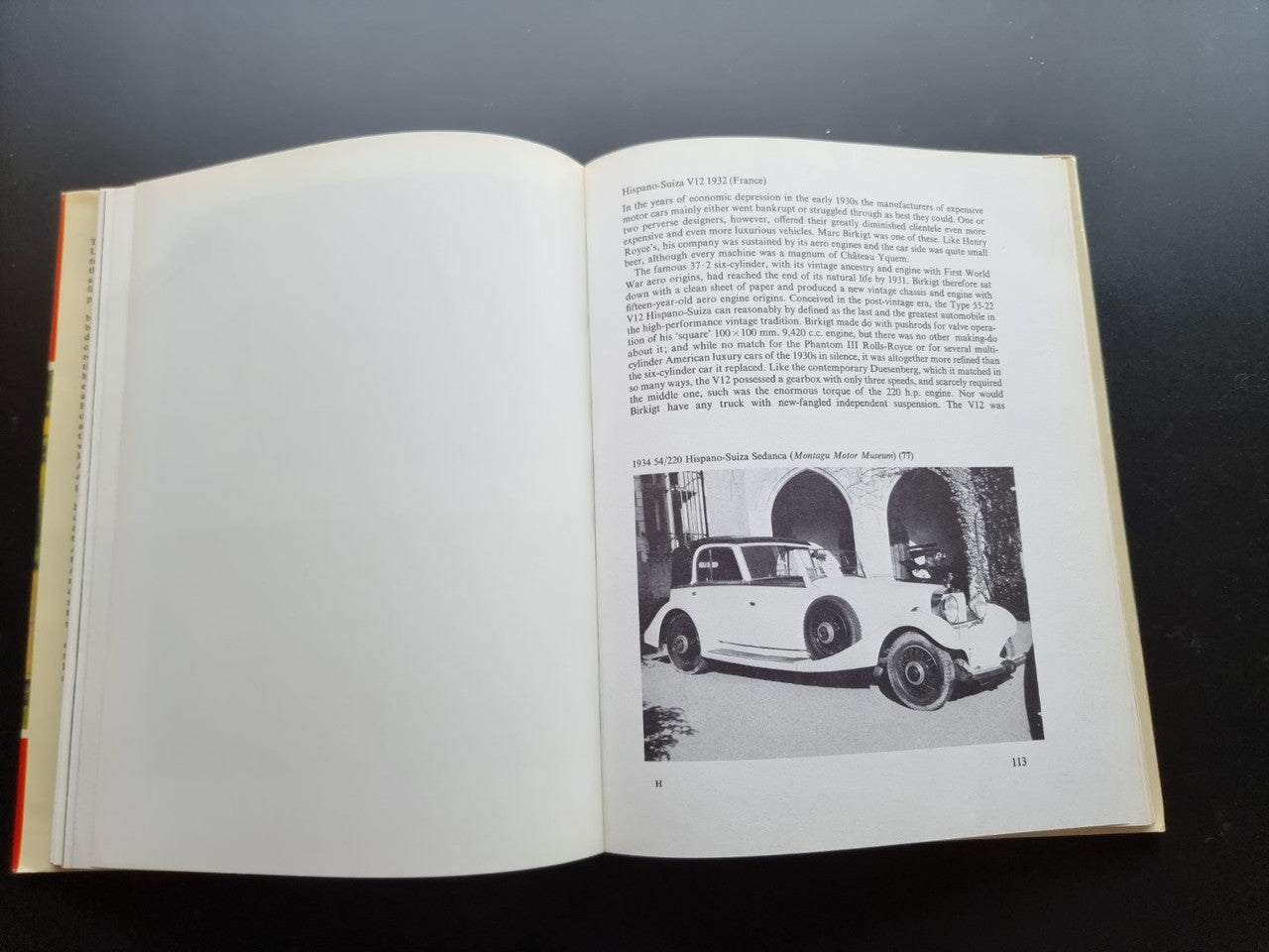 Open book page spread with paragraphs and a black-and-white photo of a vintage car.